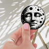 Celestial Moon Face Vinyl Sticker 2x2 featuring a colorful, intricate moon design. This waterproof and durable celestial moon sticker adds a magical touch to any space.
