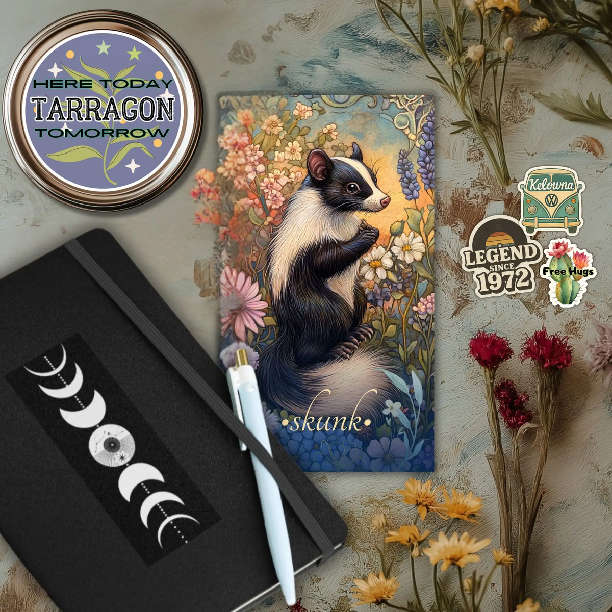 photo displaying various items sold by Canvas and Quill, including a hardcover notebook, a spice label, the Wild Urban Animal Oracle, and three stickers