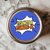 A round sticker with a comic book style that reads 'IT'S NOT A TUMOR-IC' in bold letters, placed on a marble surface.