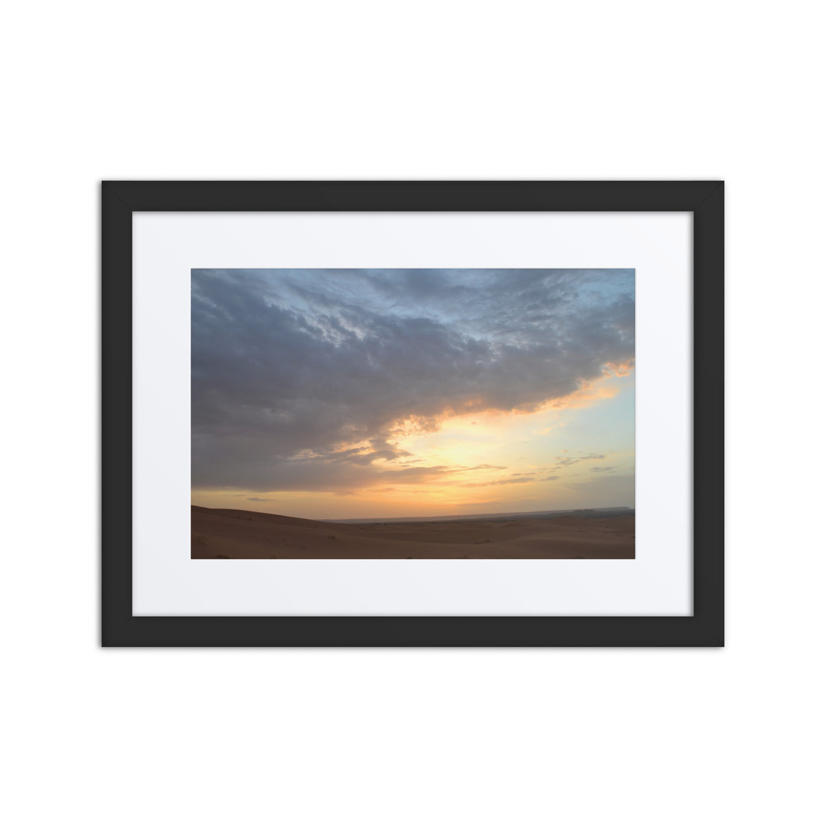 Framed photograph of a sunset over a landscape with a black frame.