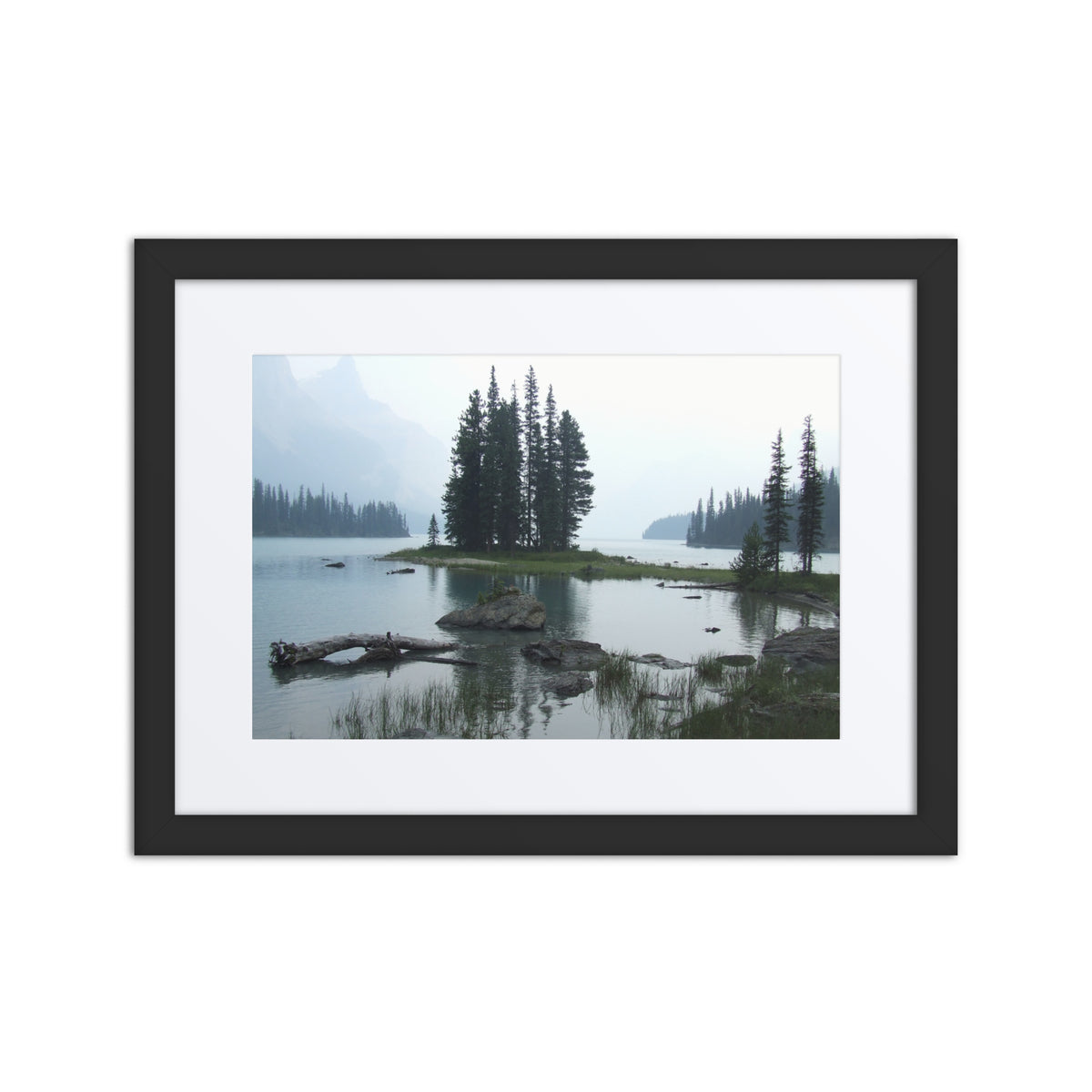 Framed photograph of a serene lake scene with trees and rocks.