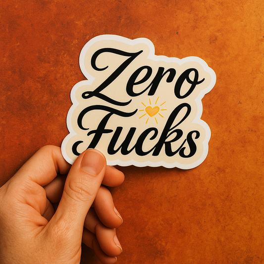 Hand holding a sticker with 'Zero Fucks' text on an orange background
