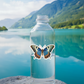 Butterfly sticker on water bottle by lake