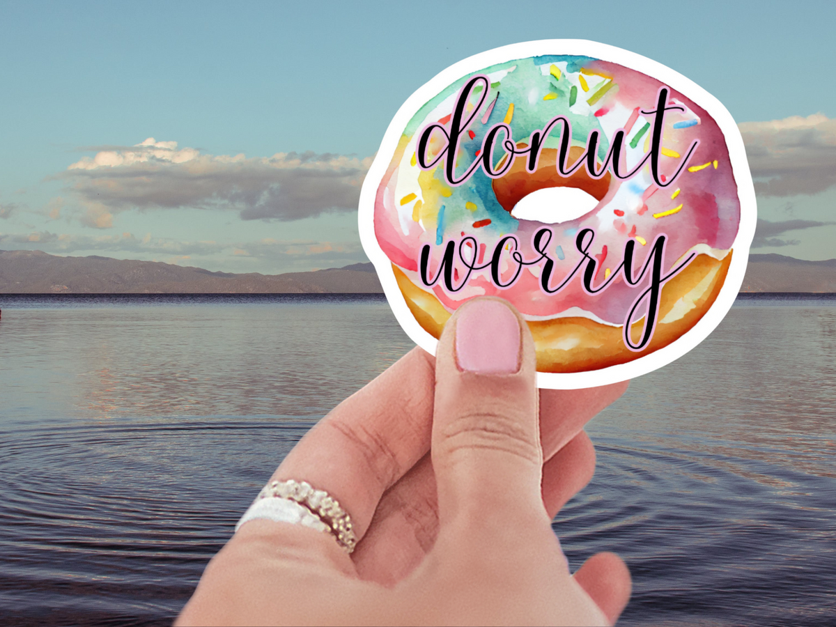 Vibrant and playful Donut Worry Waterproof Vinyl Sticker showcasing a beautifully die-cut donut design, ideal for personalizing everyday items. A must-have among donut themed stickers.
