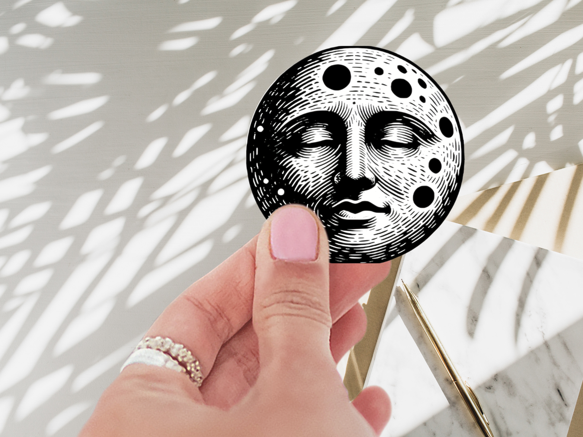 Celestial Moon Face Vinyl Sticker placed on a water bottle, demonstrating its waterproof quality and eye-catching design. Perfect celestial moon sticker for personalizing everyday items.