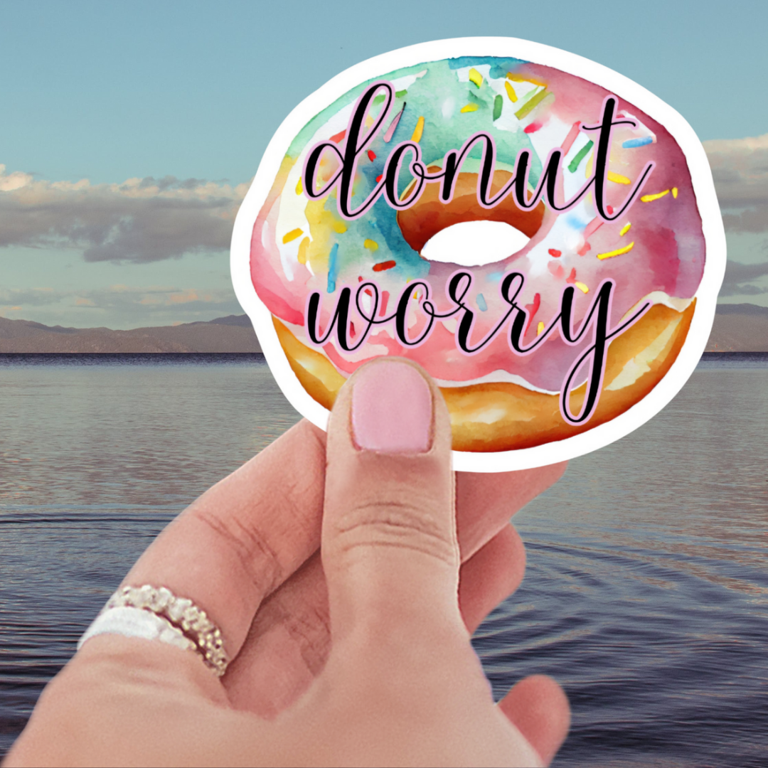 Donut Worry Waterproof Vinyl Sticker featuring a pastel icing donut with colorful sprinkles, perfect as a decoration for laptops and water bottles. A popular choice among donut themed stickers.