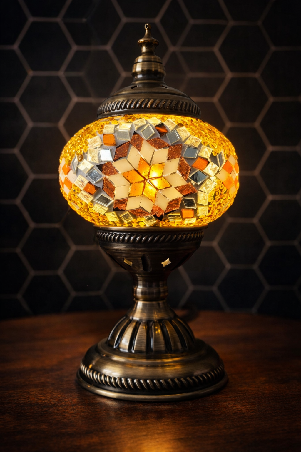 Golden Star Turkish Mosaic Lamp lit at dusk, highlighting its antique-style metal base and shimmering mosaic.
